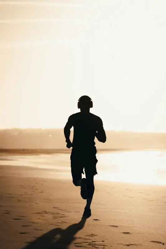 Man running on a beach at sunset
