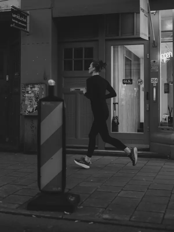 Woman running on a city sidewalk at night